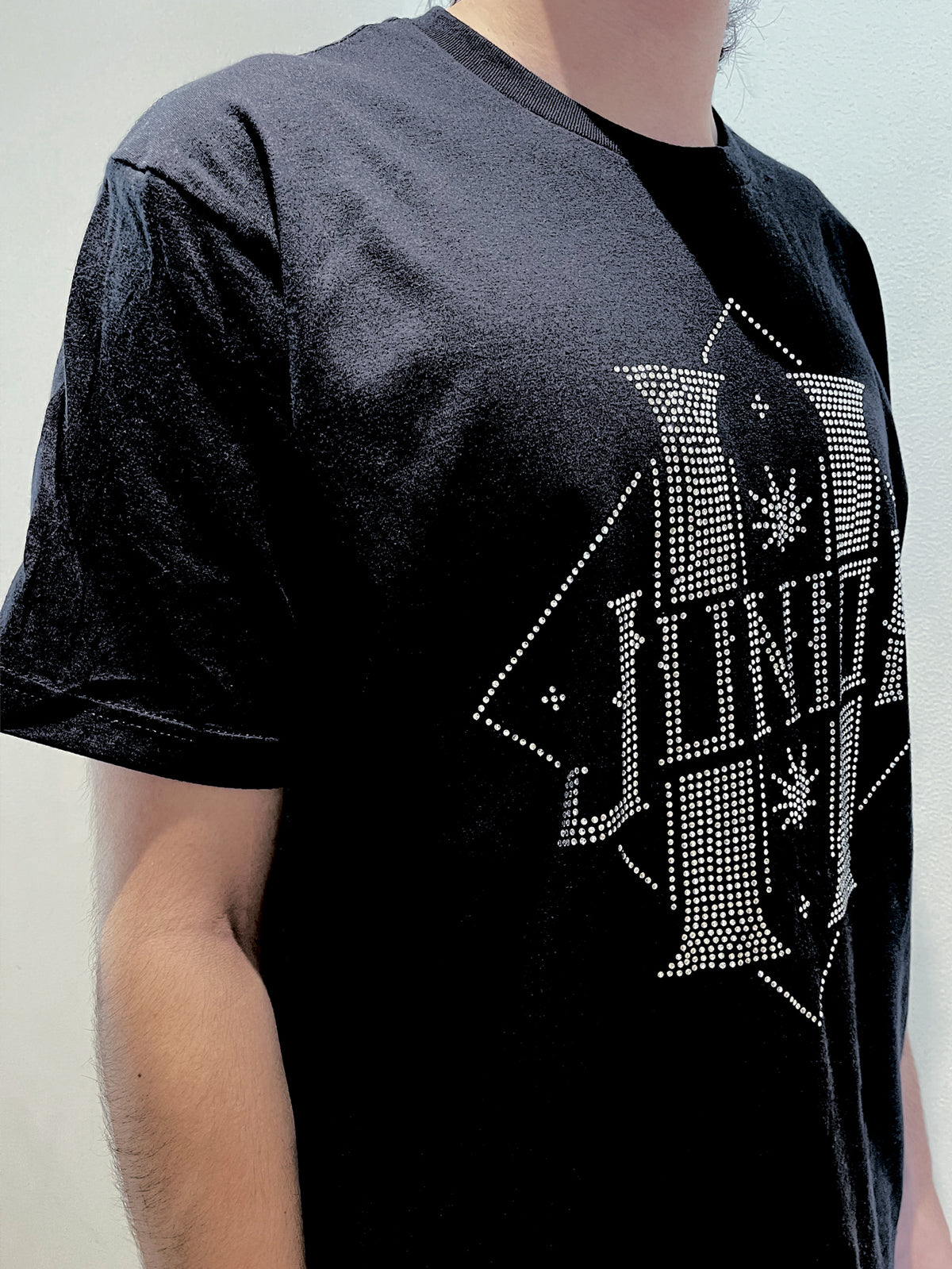 Camiseta negra Junior H logo en pedrería color plata